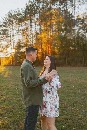 Romantic moment captured in field during golden hour sunset.