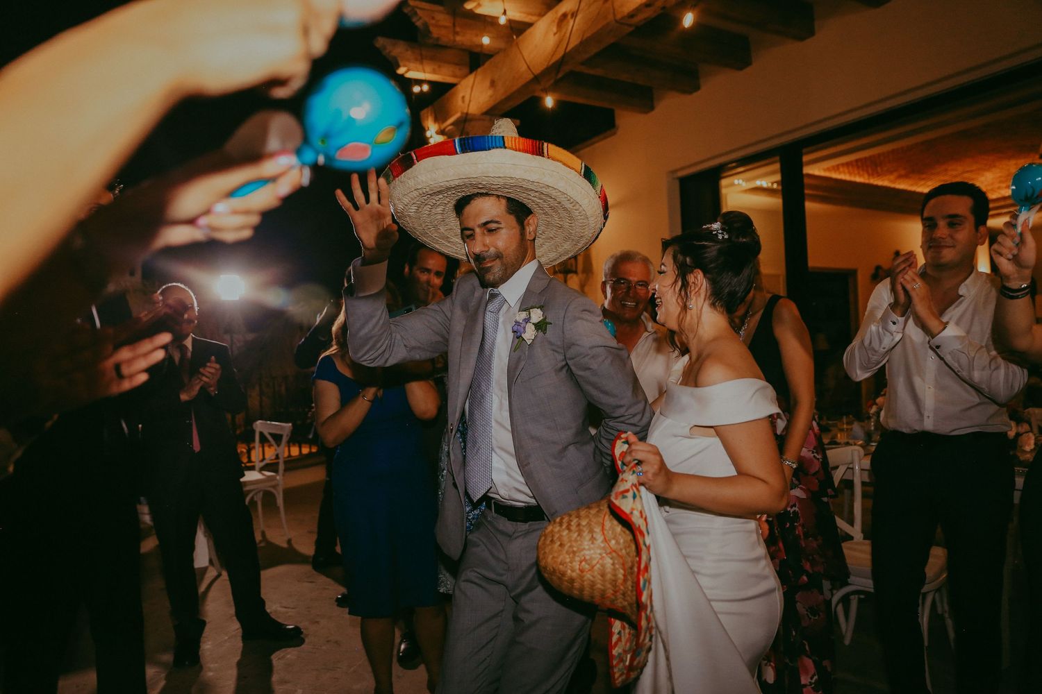 Wedding guests dance and celebrate together on a dimly lit dance floor at an evening reception.Pedregal Los Cabos Wedding Photographer
