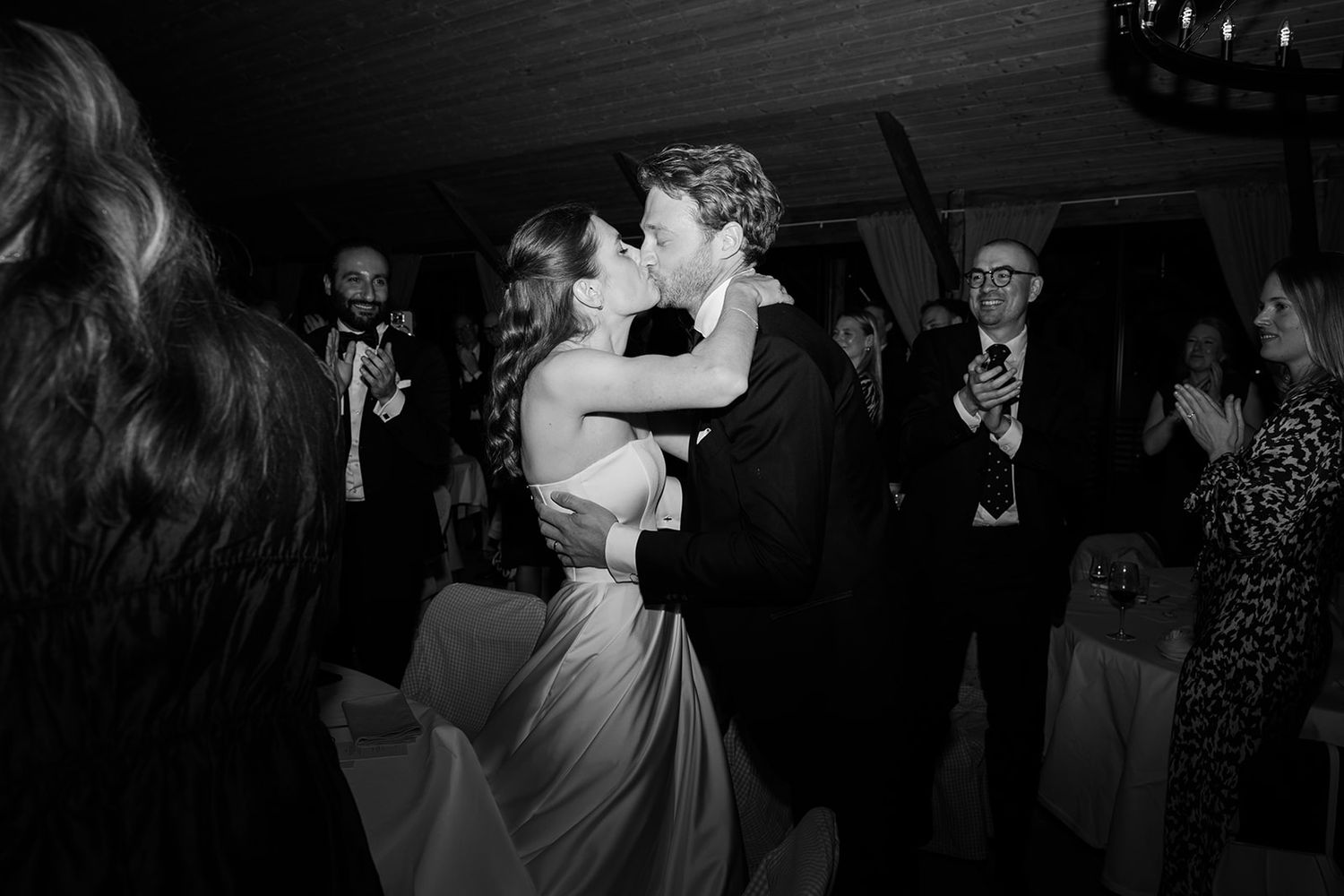 People dancing together in a dimly lit ballroom during a social dance event.