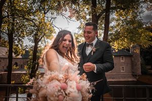 Couple embraces during sunset at their outdoor wedding celebration with autumn trees in background.