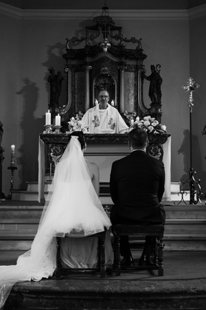 Black and white photo series showing a wedding ceremony in a traditional church with elegant decorative details.