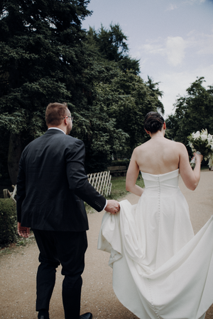 A series of wedding photos showing a couple walking together on a garden path, with the bride's white dress flowing.