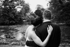 Black and white romantic silhouettes of a couple embracing in a scenic garden setting.