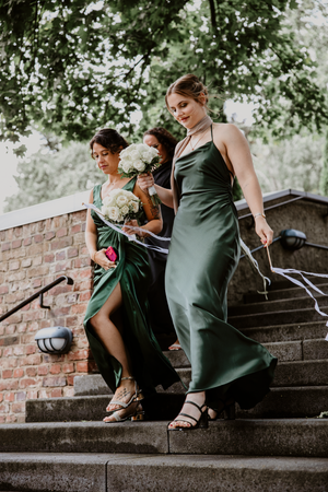 Four sequential photos show someone in a green dress sitting on stone steps in an artistic urban photoshoot setting.