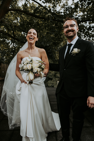 Candid black and white wedding photos showing joyful moments between newlyweds with white bouquet and formal attire.