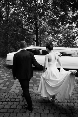 A sequence of black and white photos showing a couple in wedding attire walking together on a brick path.