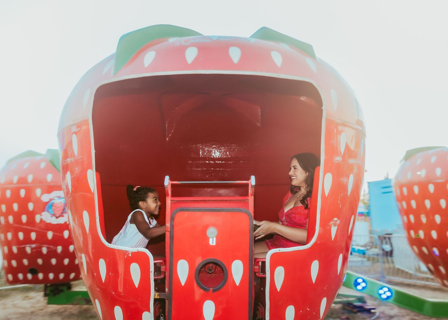 Large red strawberry-shaped building with white polka dots serves as a unique roadside attraction.