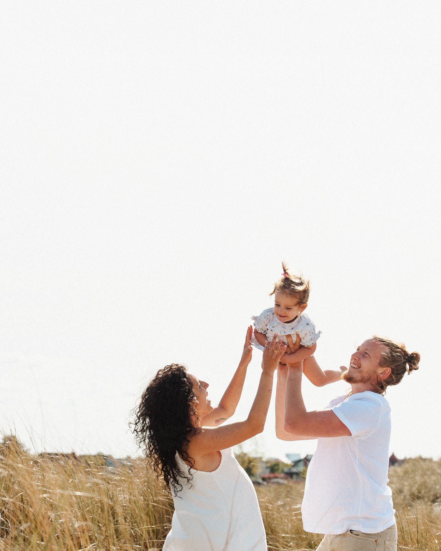 Artistic maternity photo featuring delicate baby's breath flowers against a warm brown backdrop.