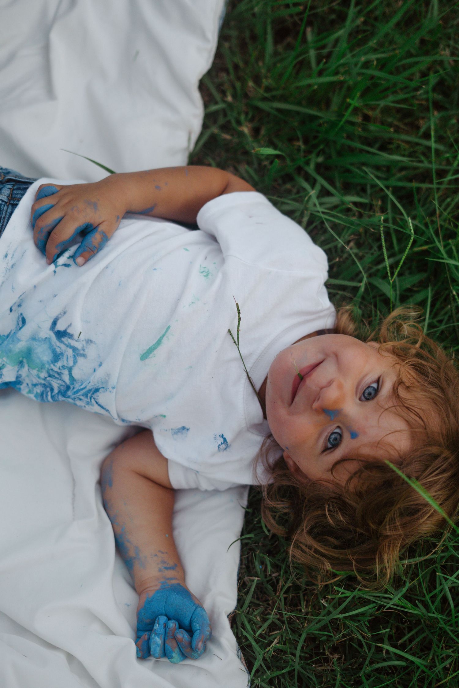 Maternity session outdoors with siblings, playful paint, colorful family photos, natural light, candid moments, lifestyle photography.