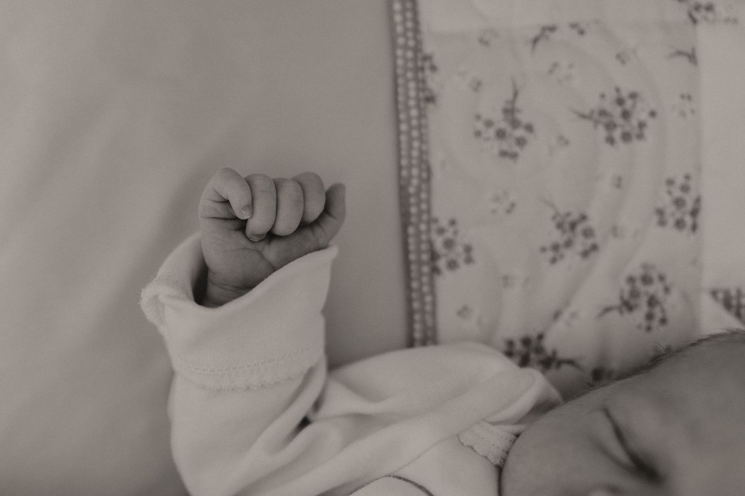 Black and white portrait of a sleeping newborn with soft textures.