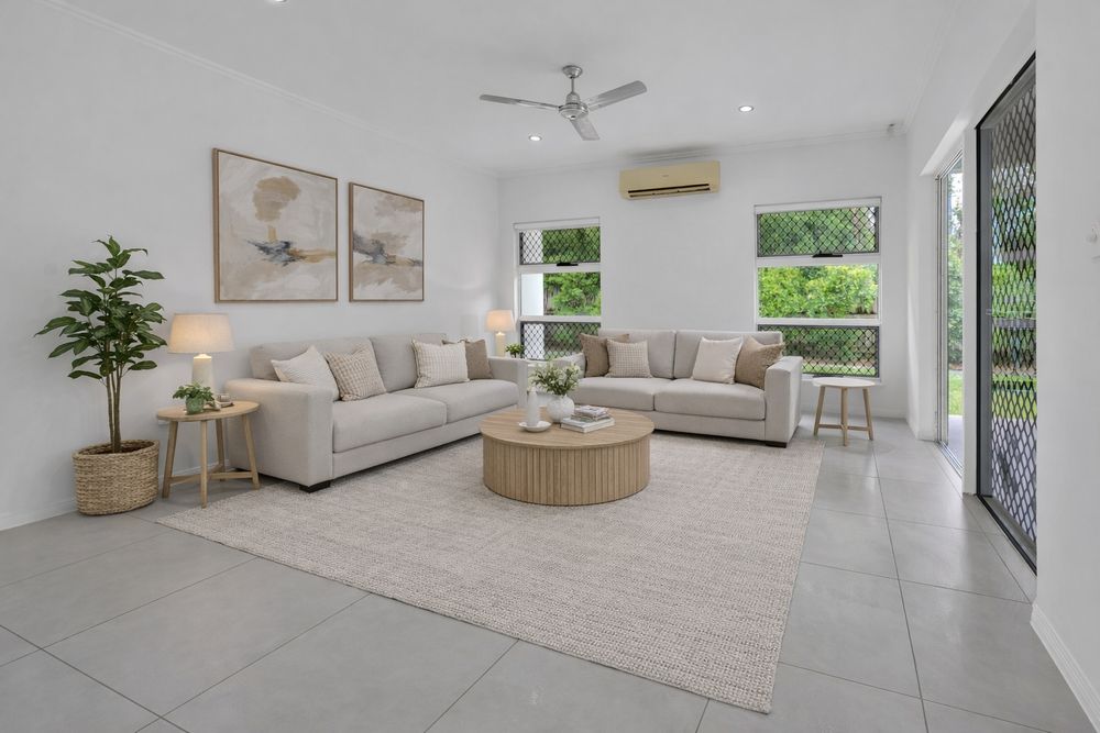 Bright contemporary living room with white tile floors, neutral furniture, and large windows overlooking greenery.
