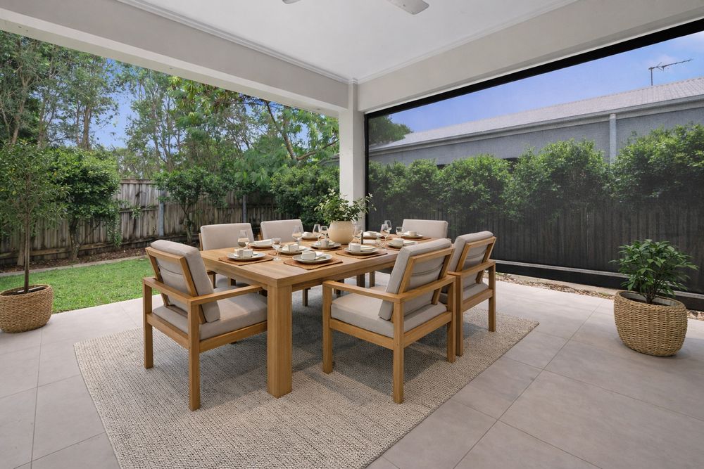 Modern outdoor patio area with wooden dining furniture and cushioned seating arranged in a covered space.