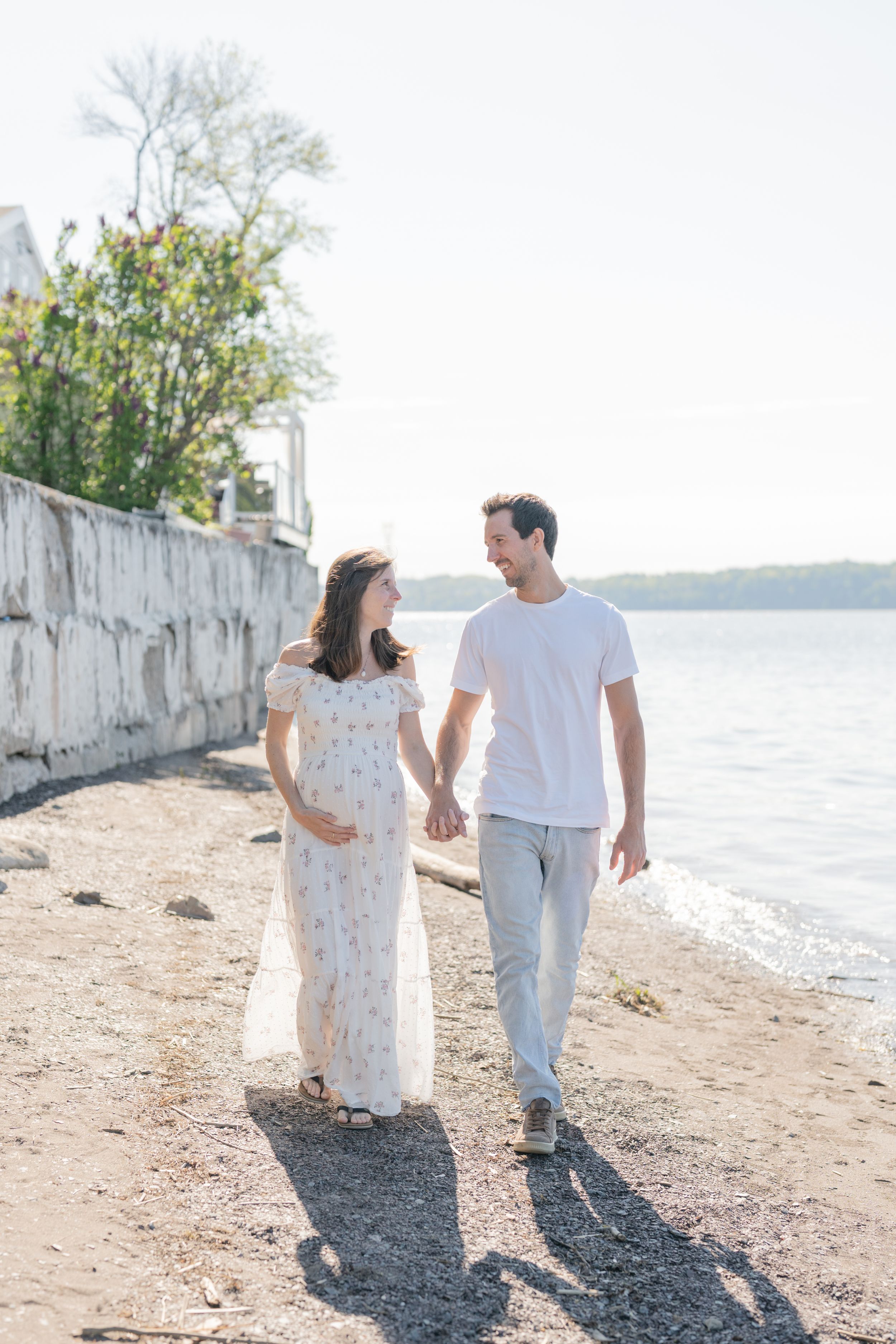 Couple marchant sur la plage lors d’une séance maternité à la marina de Cap-Rouge
