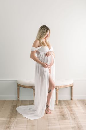 Portrait d’une future maman en réflexion, les mains posées sur son ventre