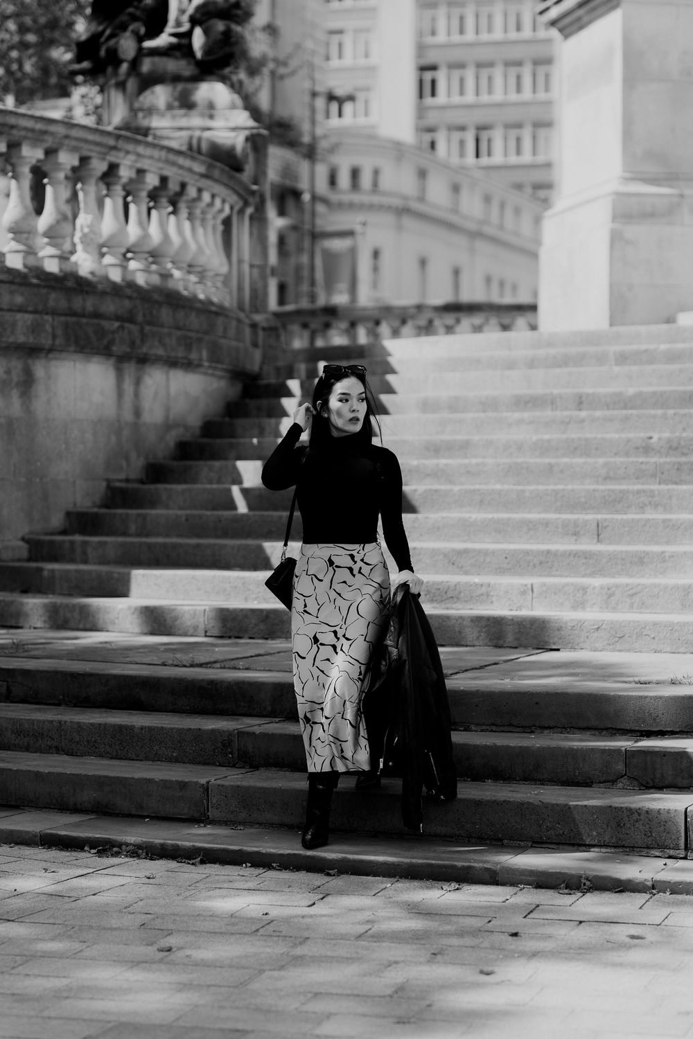 A black and white photo sequence shows two people walking down grand stone steps in an urban setting.