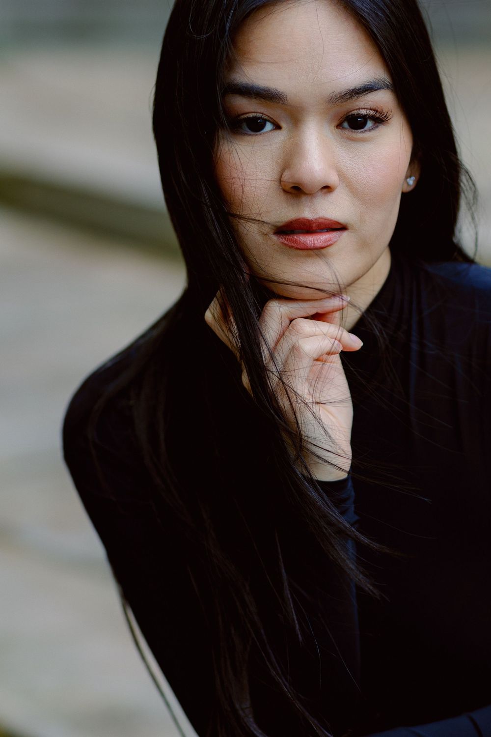 Portrait series showing artistic poses with dark hair flowing against neutral backdrop.
