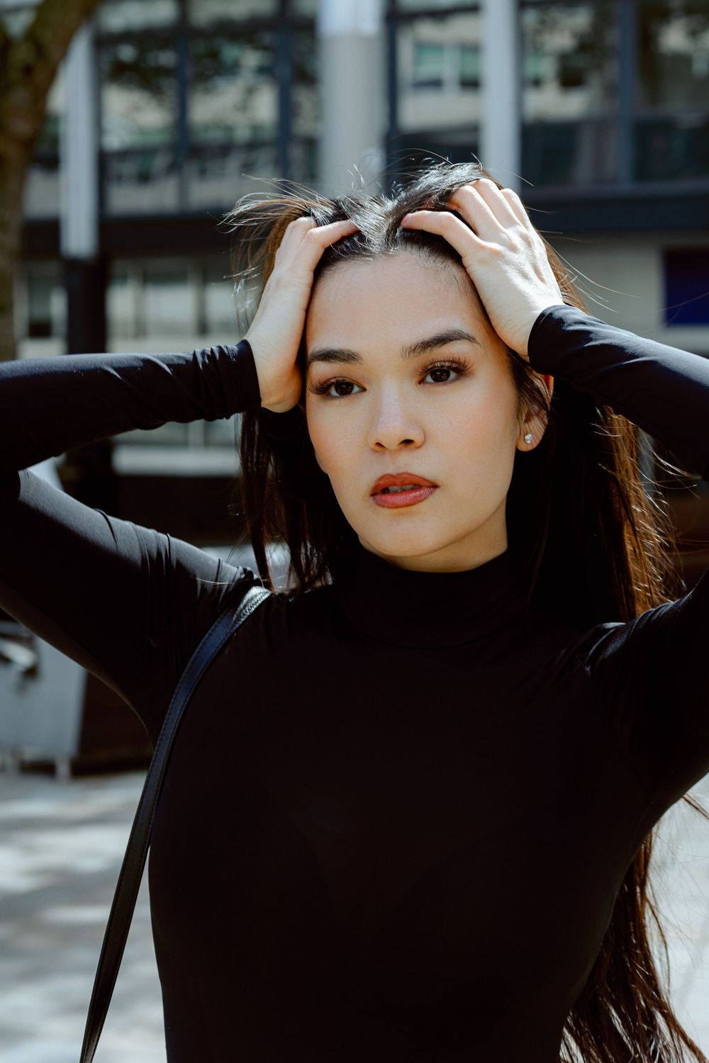 Artistic portrait with dramatic lighting and shadows against an urban background.