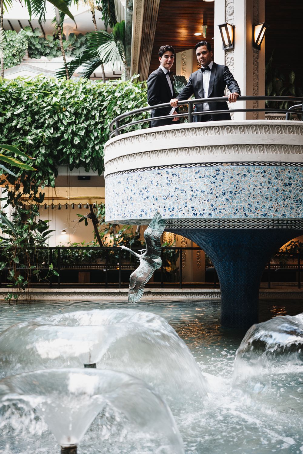 A decorative mosaic fountain with cascading water creates a peaceful ambiance in an indoor garden setting.