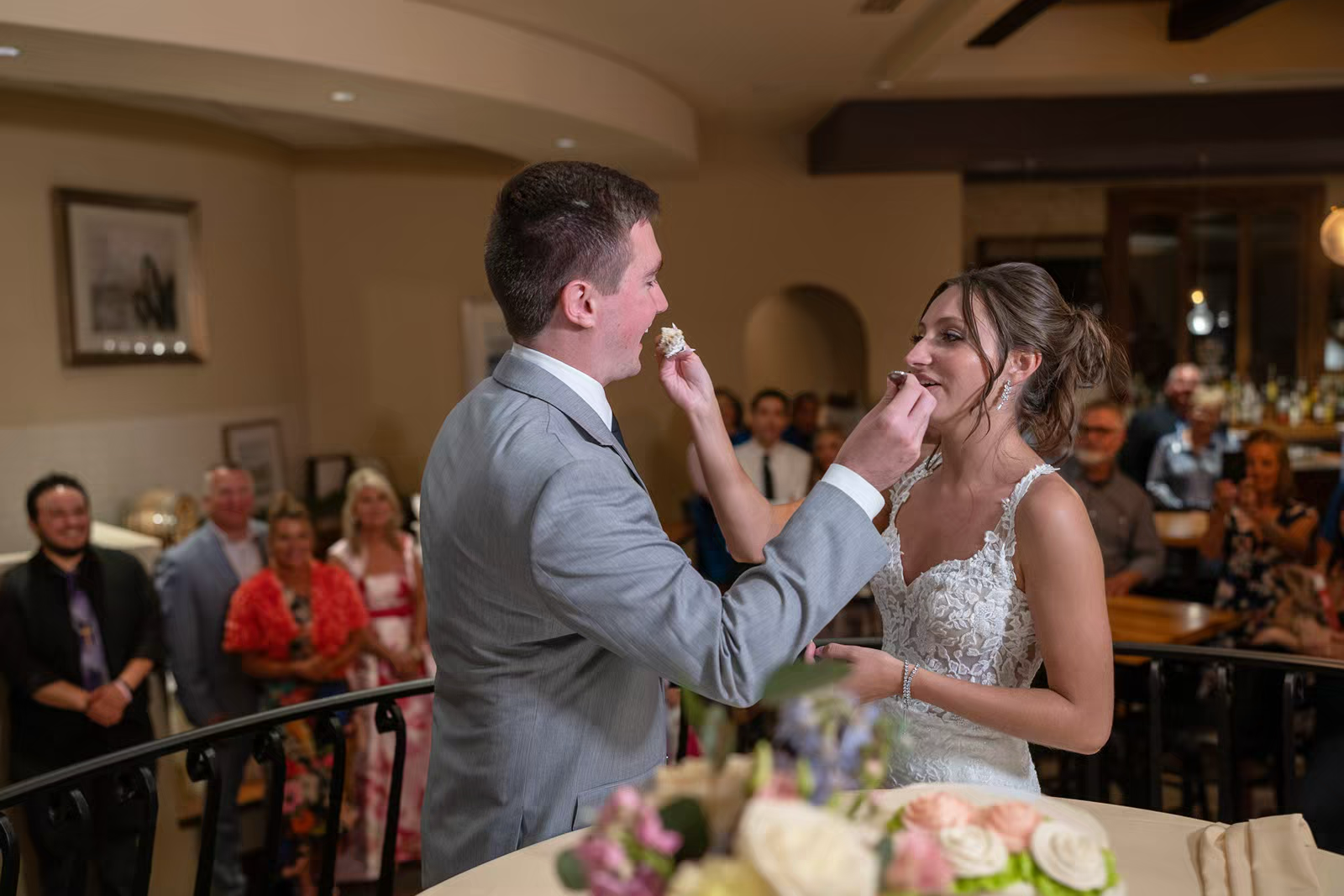 A couple shares their first dance at a wedding reception in a warmly lit indoor venue.