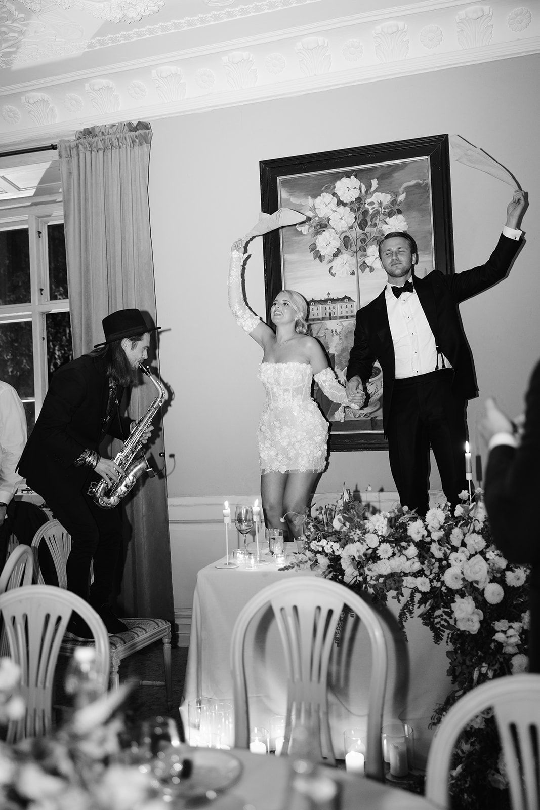 Black and white sequence of wedding reception dancing photos showing guests celebrating at tables with floral centerpieces.