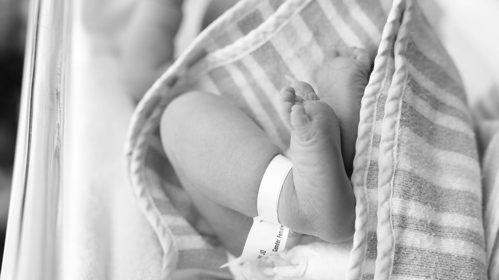 real hospital newborn photography moment capturing new parent's admiring their new baby.