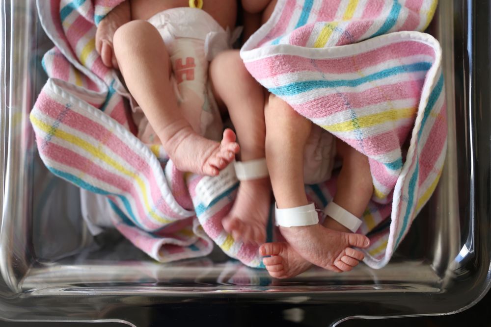 Norwest private hospital newborn photography services. Twins captured in their cot of their tiny feet and legs. Documentary story telling.