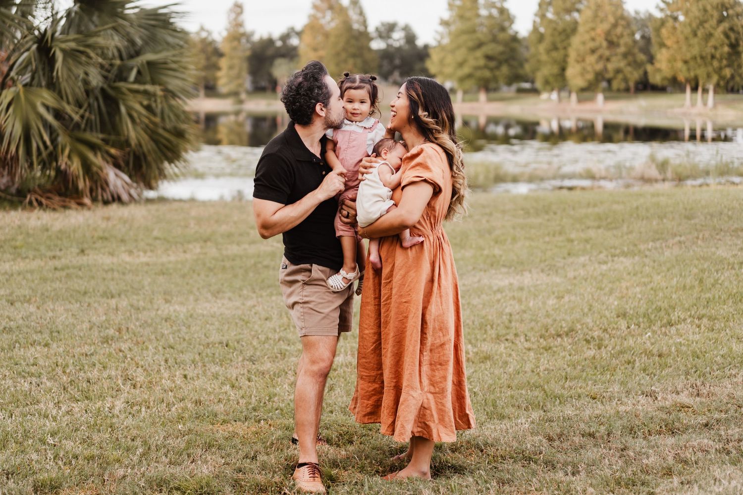 A happy family shares joyful moments together outdoors during a casual photo session in a natural setting.
