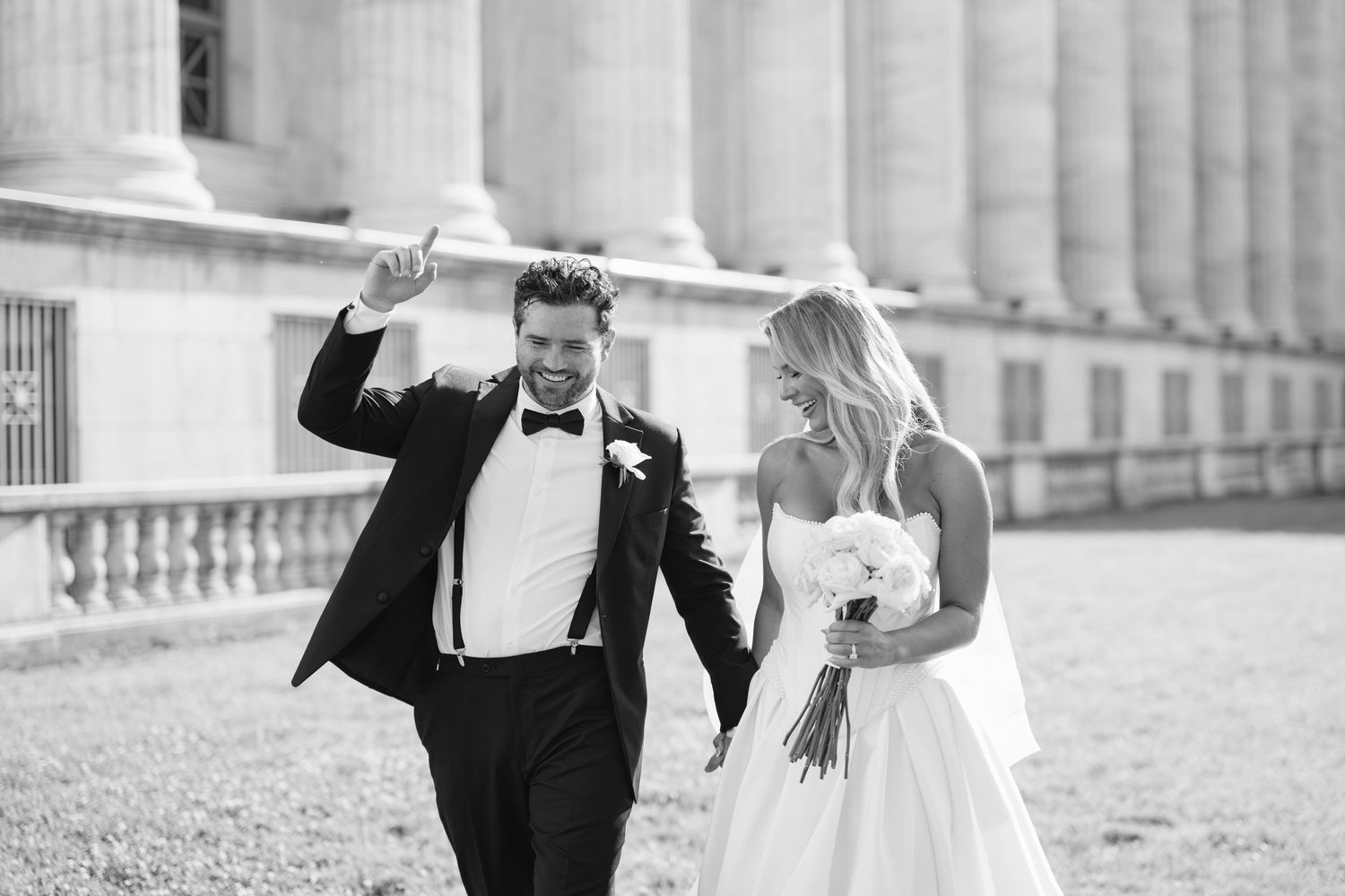 A bride and groom share joyful moments together while posing for wedding photos in a classic black and white style.