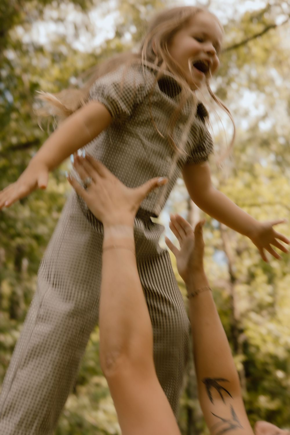 A series of images showing someone being lifted and tossed playfully in the air against a sunlit natural backdrop.
