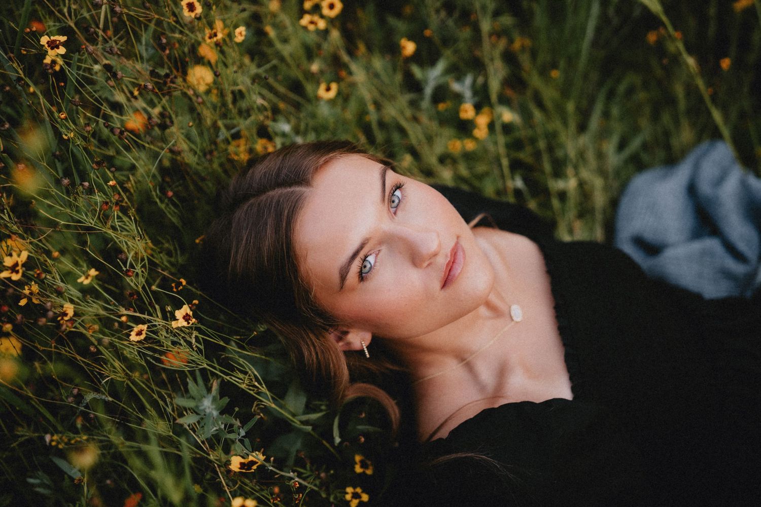 Artistic close-up shots among yellow wildflowers and grass with soft natural lighting and moody atmosphere.