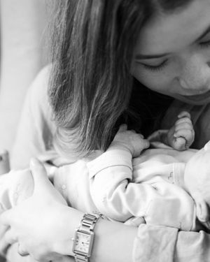 A series of black and white photos showing a tender moment between a person and a sleeping baby.