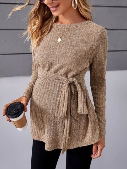 A beige ribbed sweater with side tie detail shown from different angles against a gray background.