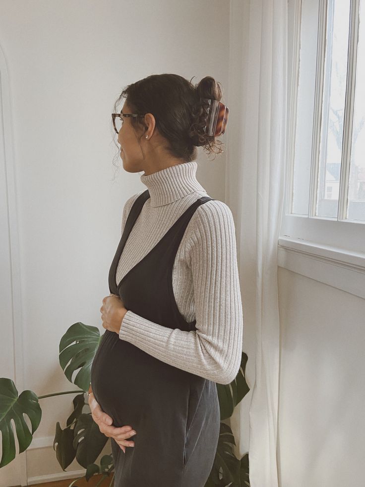 Three connected images show someone wearing a black sleeveless dress and white turtleneck sweater posing in a bright room.