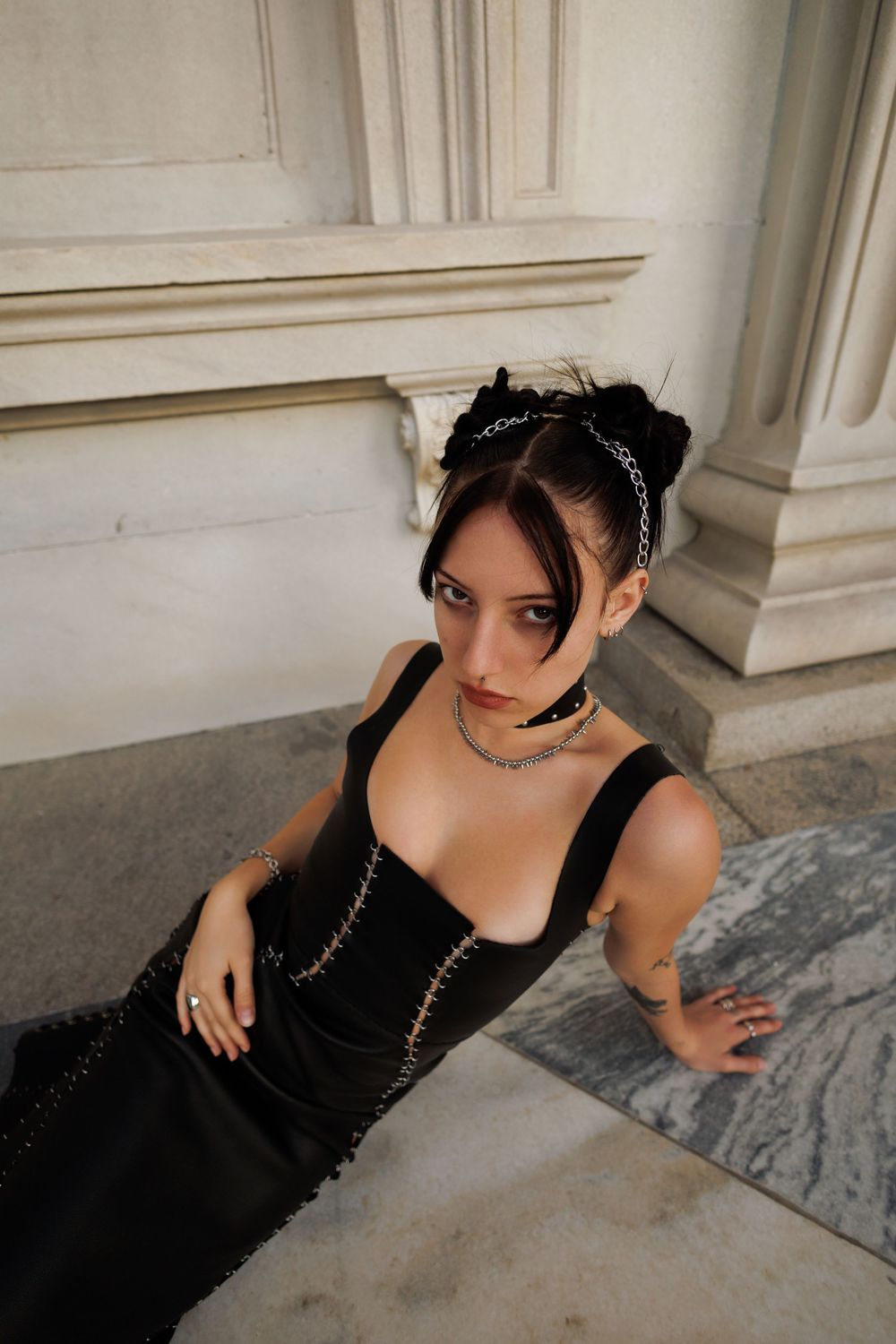A series of elegant portraits showing someone in a black evening gown posing against a marble backdrop.