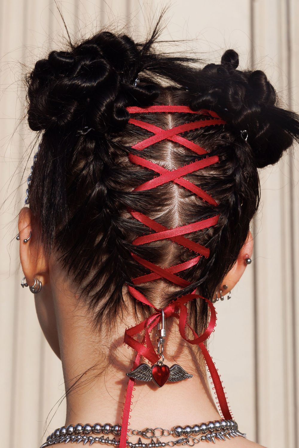 Multiple views of black hair styled in an updo with red ribbon woven in a corset pattern through the back.