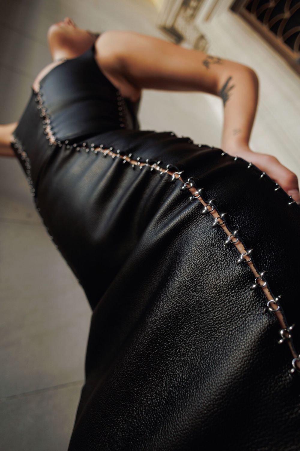 Close-up of leather moccasin being hand-stitched with white thread showing detailed craftsmanship progress.