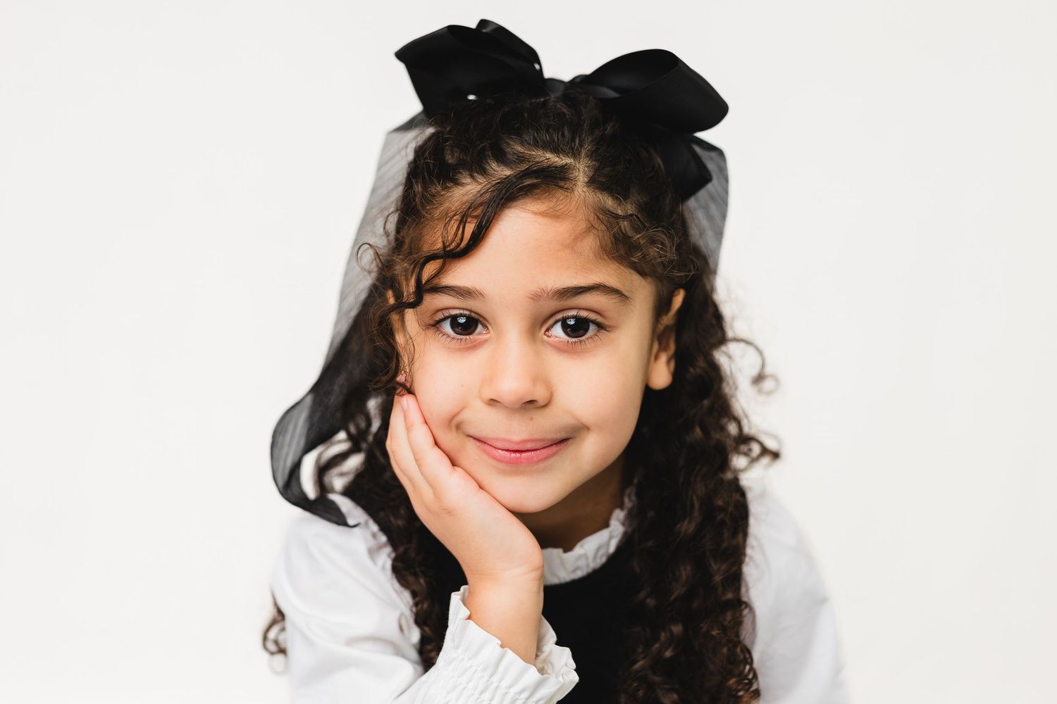 A series of headshots showing joyful expressions while wearing green outerwear against a plain white background.
