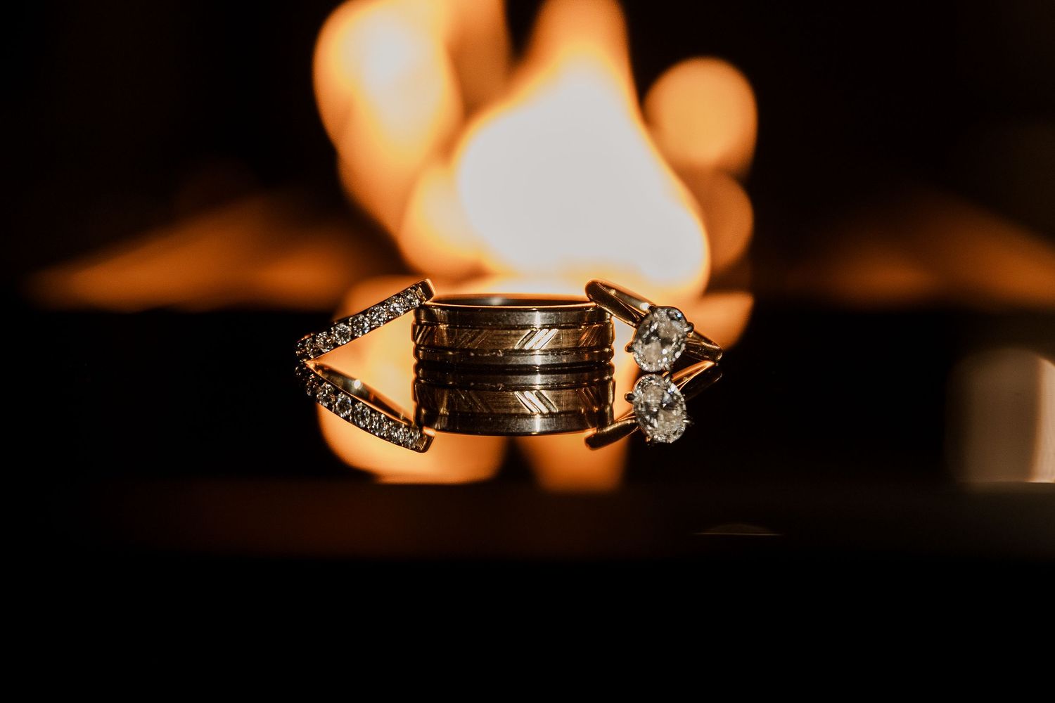 Wedding rings photographed with dramatic lighting and shadows creating an artistic composition.