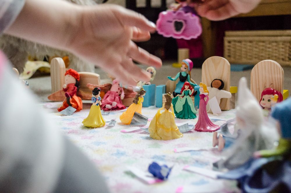 Colorful wooden toy figures are arranged on a table for creative play.