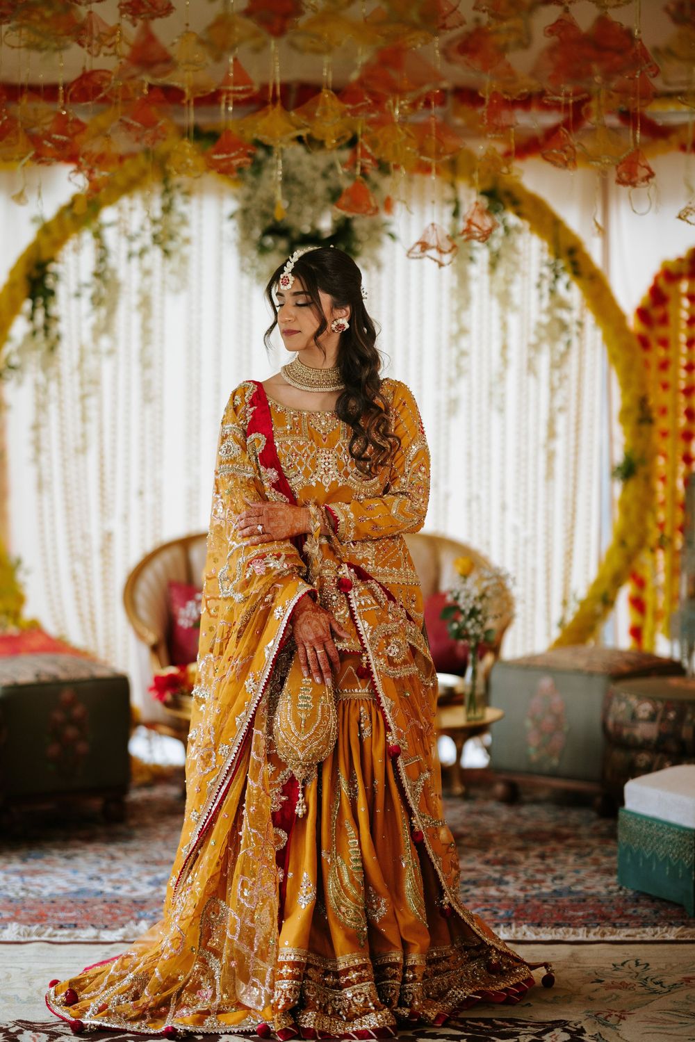 Traditional Indian bridal attire featuring an ornate gold and red lehenga with intricate embroidery and embellishments.