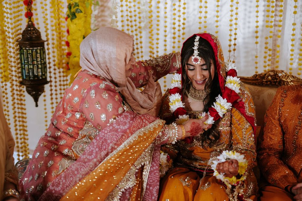 Traditional Indian wedding ceremony with colorful garlands and decorations against a yellow beaded backdrop.