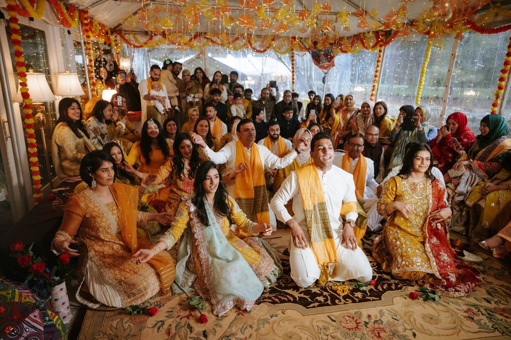 Colorful traditional Indian wedding ceremony with guests seated in rows watching the cultural celebrations.