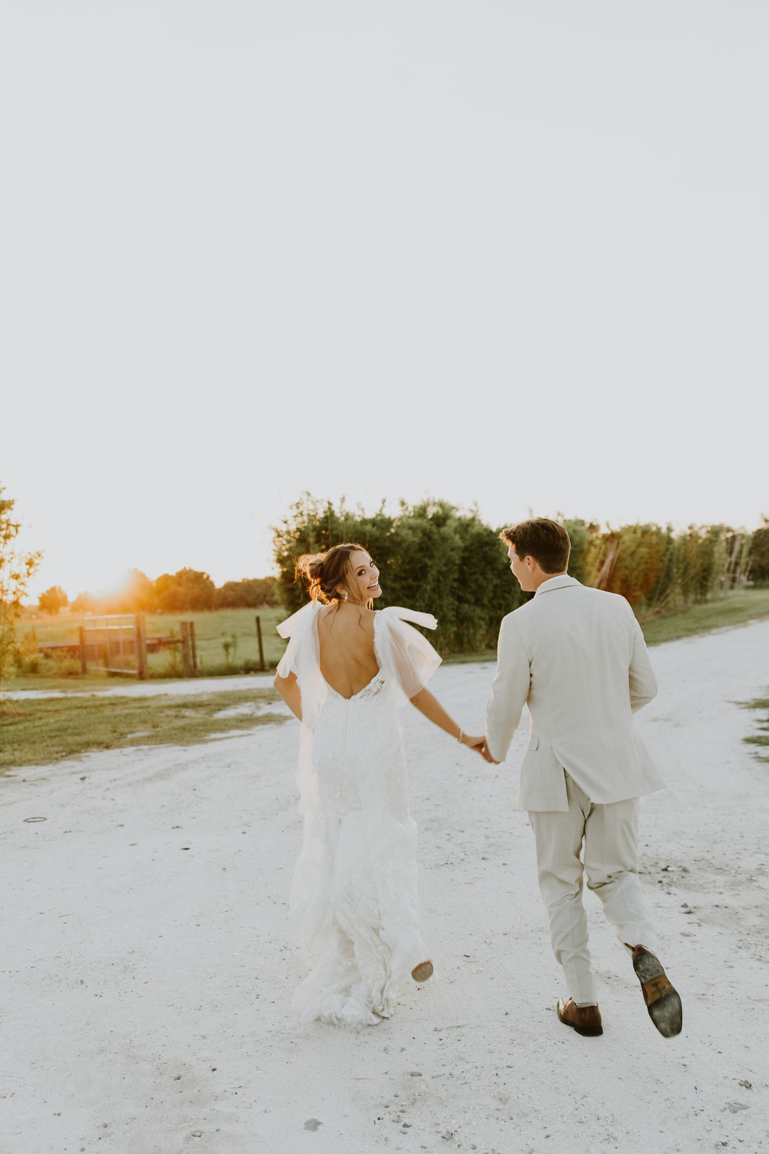 Summer engagement session on the beach in Juno. Couple portraits by the pier, in water, and in the golden sunrise light