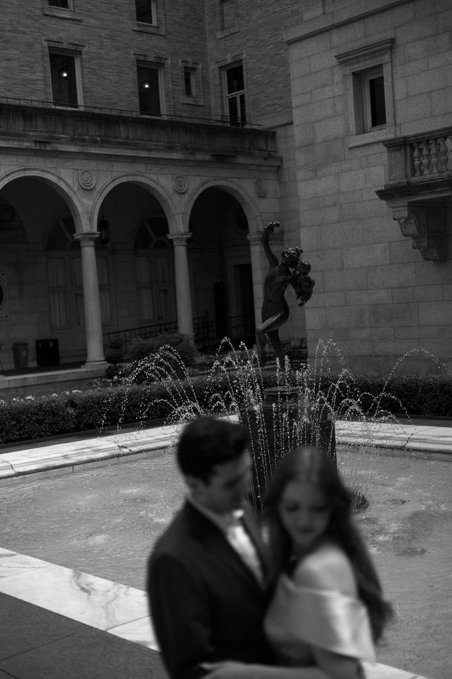 A vintage fountain display in a historic stone courtyard shows multiple water jets creating elegant arcs and patterns.