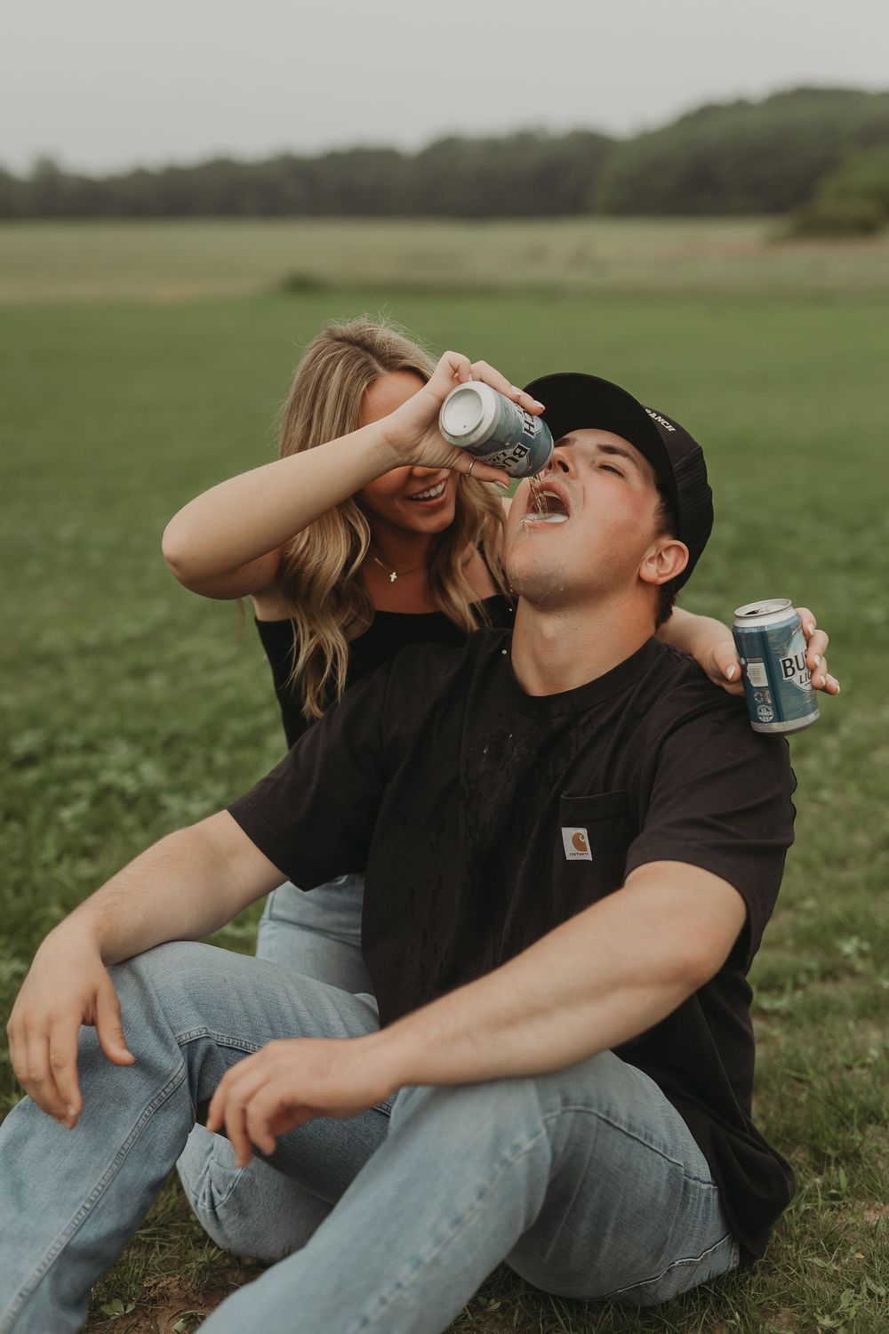 Person in black shirt and jeans sits outdoors on grass while drinking from a can in progression of shots.