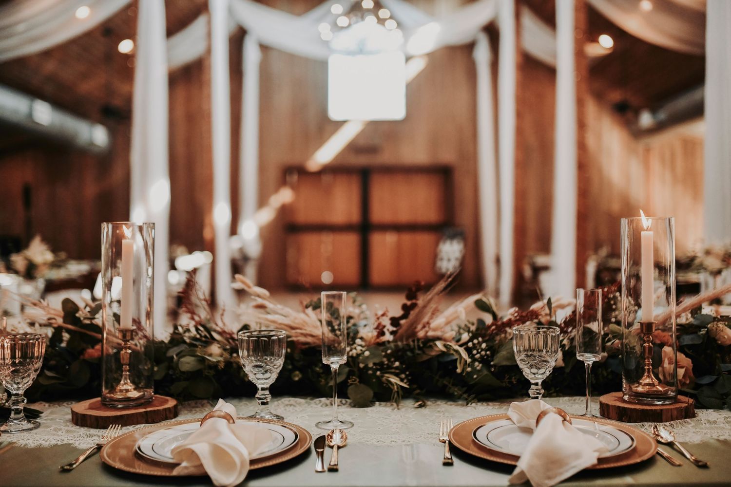 Elegant rustic wedding décor with floating candles, loose greenery, and votives