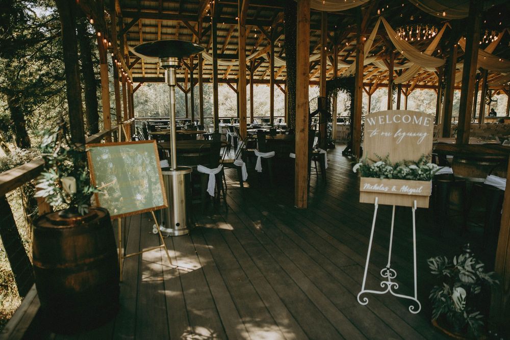 Rustic wooden wedding venue with natural light streaming through windows and decorative hanging elements.