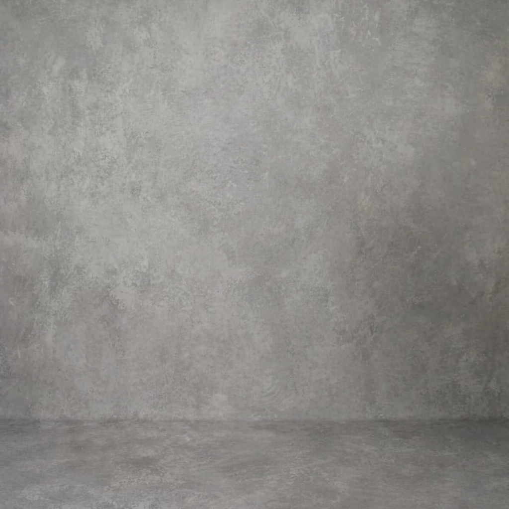 Empty concrete room with gray textured walls and floor creating a minimalist industrial backdrop.