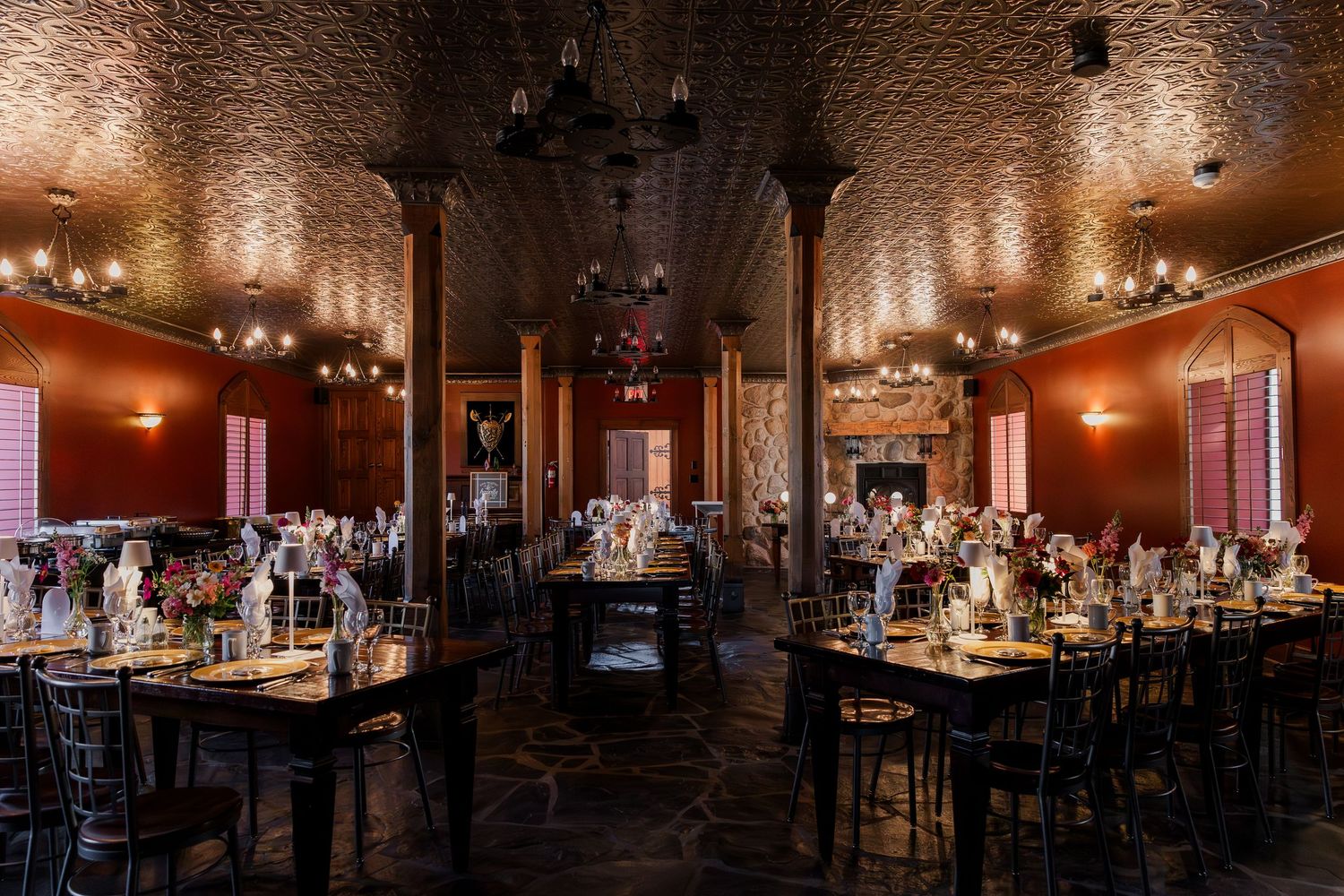 Wide angle shot of a wedding reception hall with ornate ceiling and moody lighting at at Hauser Hall in Kitchener, Ontario.