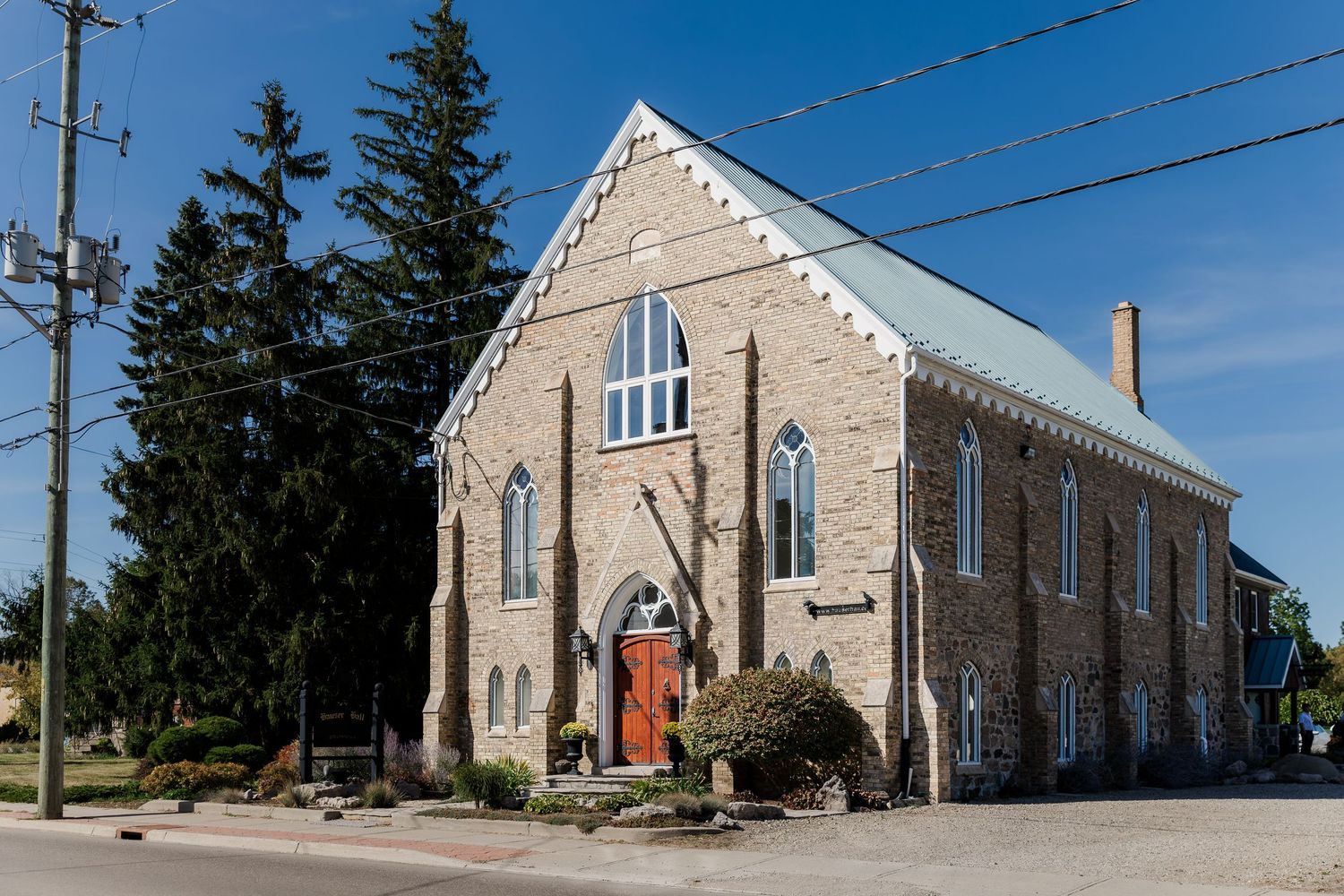Stone church building with Gothic architecture features Hauser Hall in Kitchener, Ontario.